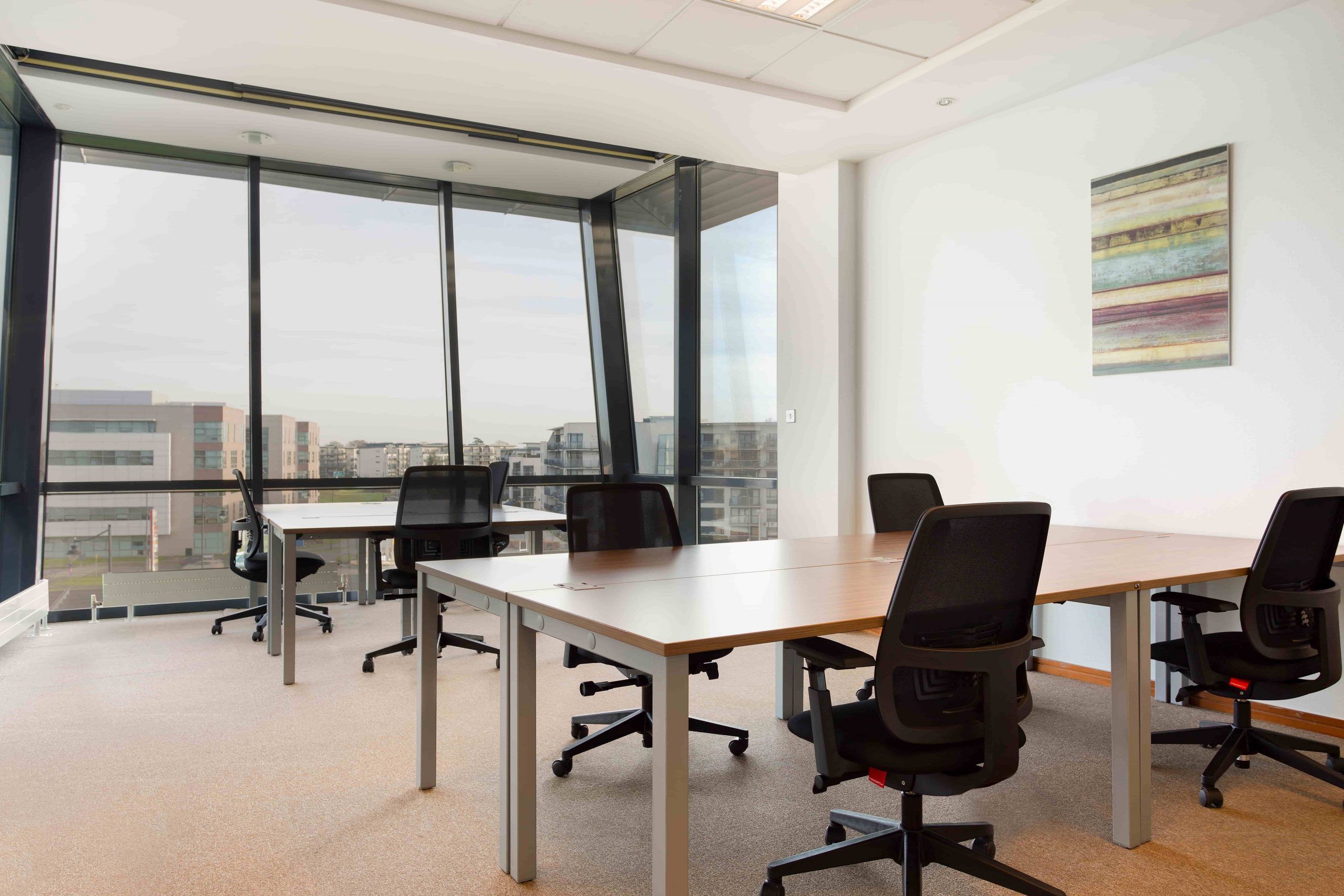 Modern private office with desks, natural light and a professional workspace arrangement