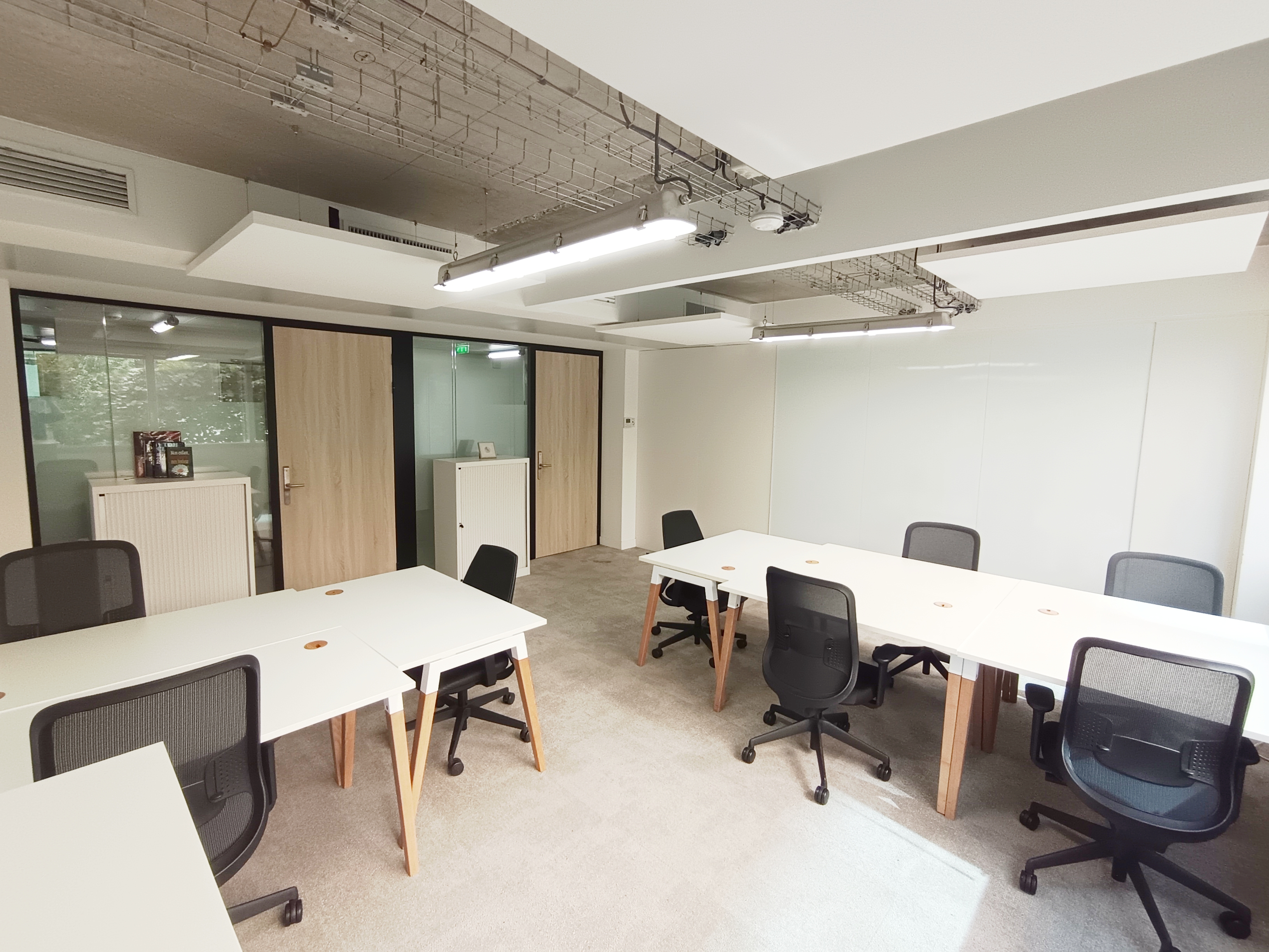 Organized professional office workspace with private areas, desks and connected meeting spaces